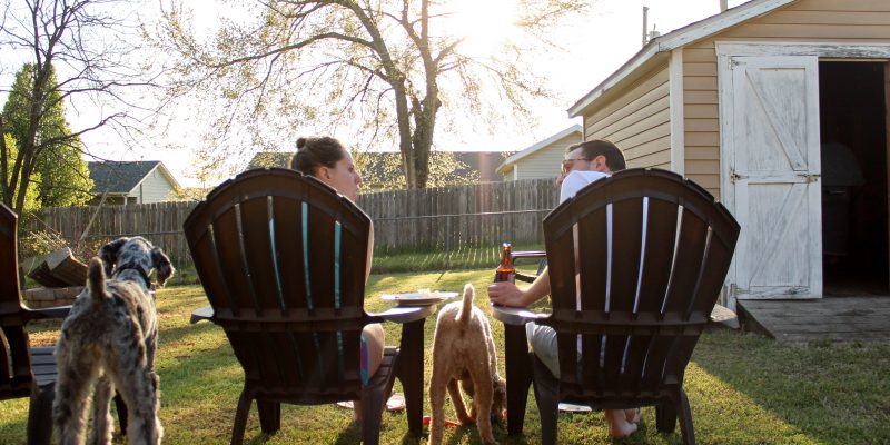 Woman and man sitting in lawn chairs next to two dogs